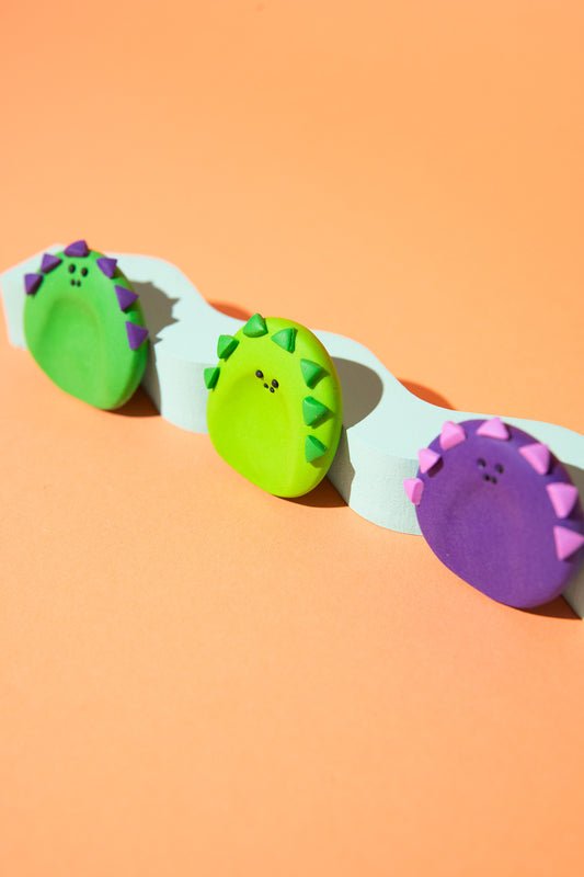 Handgefertigter Dino-Sorgenstein aus Polymer Clay mit strukturierter Zackenoberfläche und glatter Rückseite.